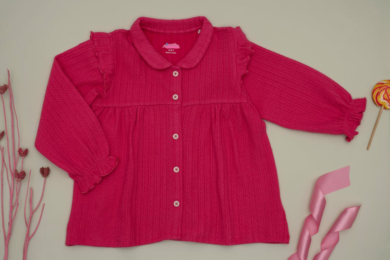 services-01 A vibrant pink long sleeve blouse with decorative elements, perfect for children's fashion.